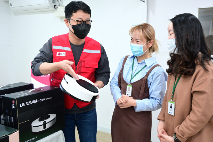 LG전자 임직원으로 구성된 '라이프스굿 봉사단'이 대한사회복지회 암사재활원 관계자에게 물걸레 전용 로봇청소기 ‘코드제로 오브제컬렉션 M9’ 사용법을 안내하고 있다. / 사진=LG전자