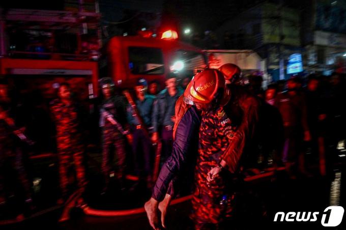 [사진] 화재 발셍 방글라 쇼핑몰서 부상자 옮기는 소방대원