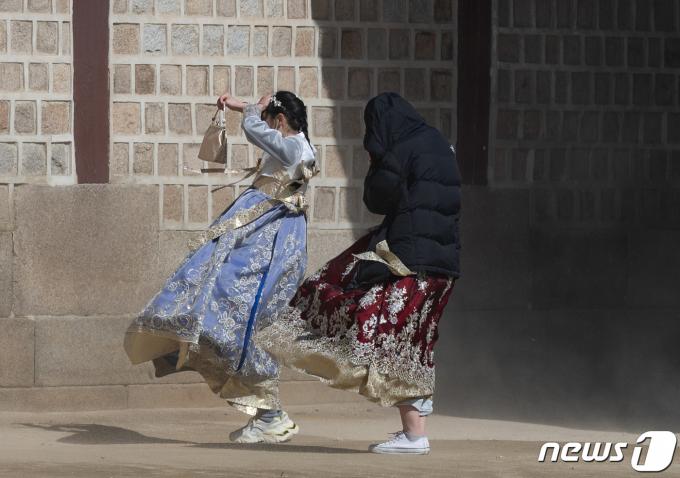 꽃샘추위가 찾아온 1일 오후 서울 종로구 경복궁을 찾은 외국인 관광객들이 바람에 날리는 모래를 피하고 있다. 2024.3.1/뉴스1 ⓒ News1 이재명 기자