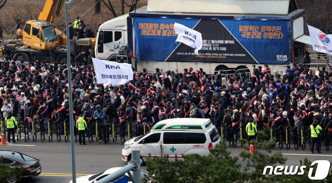 [사진] 의료 차질 이번 주 고비…시위대 옆을 지나는 구급차