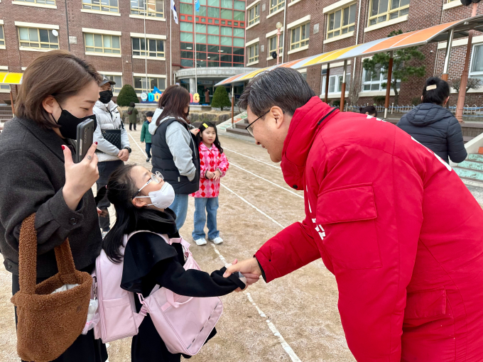 김대식 국민의힘 예비후보(오른쪽)가 사상구에 있는 한 초등학교에서 입학생과 인사를 나누고 있다. /사진=김대식캠프