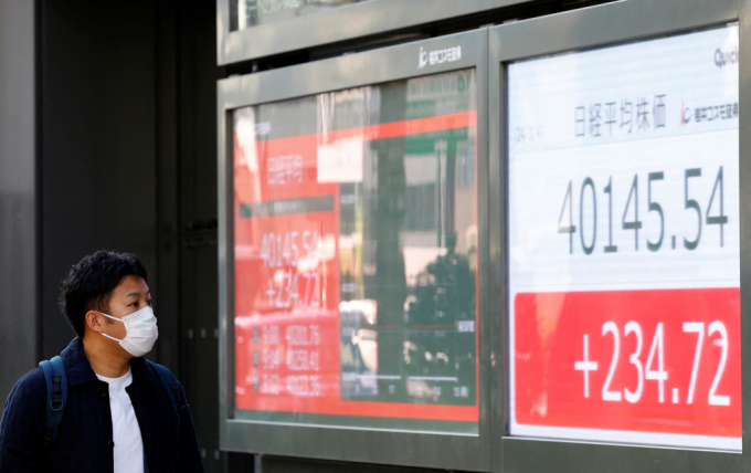  4일 일본 도쿄에서 한 남성이 사상 처음으로 4만 엔을 넘긴 일본 증시 현황 전광판을 바라보고 있다./사진=로이터
