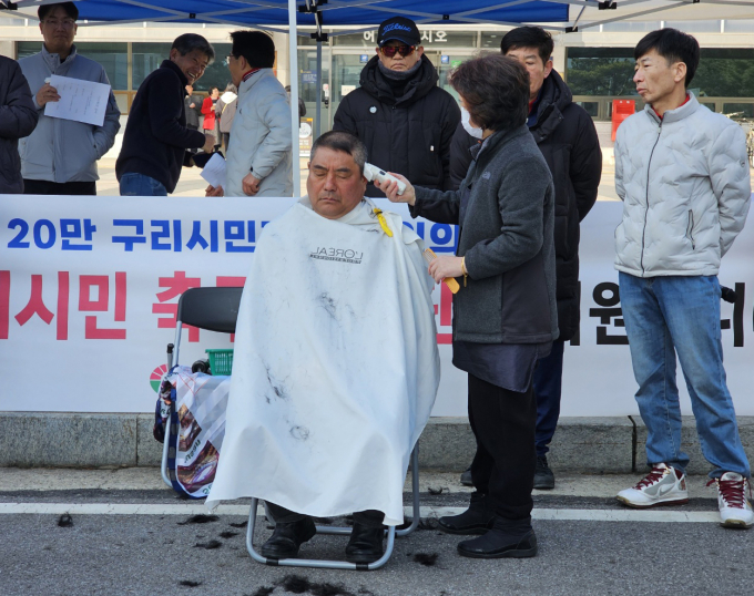 이재선 구리시축구협회 협회장이 회원들이 지켜보고 있는 가운데 삭발을 하고 있다. /사진=이건구 기자