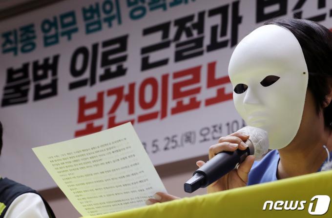 가면을 쓴 의료기관 소속 PA 간호사가 25일 서울 영등포구 전국보건의료산업노조 사무실에서 열린 '보건의료 근본 과제 해결 촉구' 기자회견에서 직종 업무 범위 명확화, 무면허 불법 의료 근절, 간호사 처우개선 등을 촉구하고 있다. 2023.5.25/뉴스1 ⓒ News1 이동해 기자