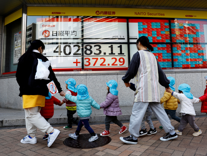 일본의 1월 실질 임금이 22개월째 감소했다. 사진은 지난 4일 일본 도쿄의 한 증권사 밖에서 일본 닛케이 주가 평균을 표시하는 전자 스크린 앞을 아이들과 교사들이 지나가고 있는 모습. /사진=로이터