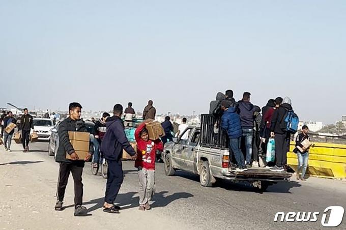 지난 2일(현지시간) 팔레스타인 가자 지구의 해변에서 미국 항공기가 공중서 투하한 식량 박스를 주민들이 들고 가고 있다. 2024.3. 4 ⓒ AFP=뉴스1 ⓒ News1 우동명 기자