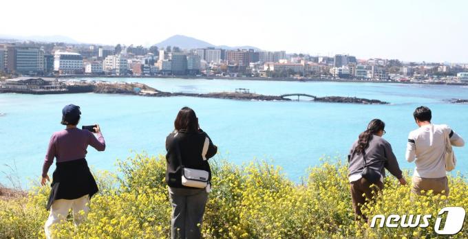 10일 제주도민과 관광객 등이 제주시 조천읍 서우봉에 핀 유채꽃과 함덕 해수욕장을 배경으로 사진촬영을 하고 있다.2024.3.10./뉴스1 ⓒ News1 강승남 기자