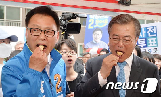 문재인 더불어민주당 전 대표가 6일 오후 경기도 수원시 영통구의 한 아파트 단지에서 열린 박광온(수원정) 후보 지원유세에서 박 후보와 어묵을 맛보고 있다. 2016.4.6/뉴스1 ⓒ News1 이재명 기자
