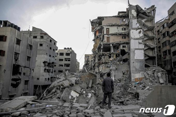 지난 3일(현지시간) 가자지구에서 한 주민이 이스라엘과 팔레스타인 무장정파 하마스 사이에 벌어진 전쟁으로 폐허가 된 주택가 한가운데 서 있다. 2024.03.03/ ⓒ AFP=뉴스1 ⓒ News1 권진영 기자