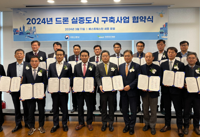 황규범 성남시 4차 산업추진단장(앞줄 오른쪽 두번째)이 11일 오후 2시 세종특별자치시 국책연구단지 베스트웨스턴플러스 토파즈룸에서 실증도시 17개 지자체 관계자들과 함께 '2024년 드론 실증도시 구축사업'에 대한 업무협약'을 체결한 후 기념촬영을 하고 있다. / 사진제공=성남시