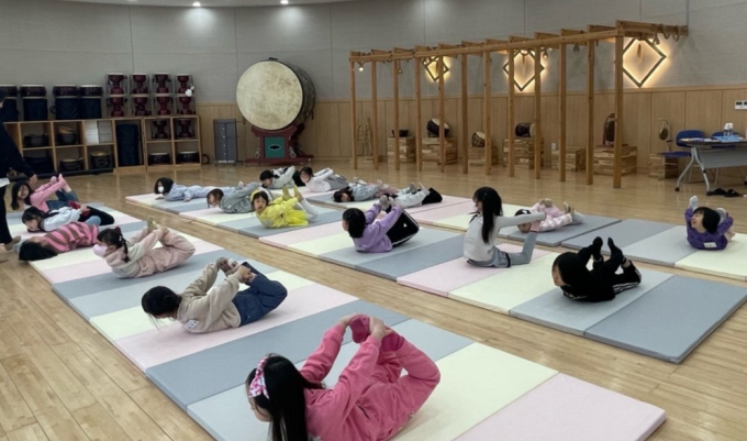 ‘MY 드리밍’수업에 참여한 아이들이 아리랑 전수관, 매트에서  스트레칭으로 몸을 풀고 있다./사진=밀양시