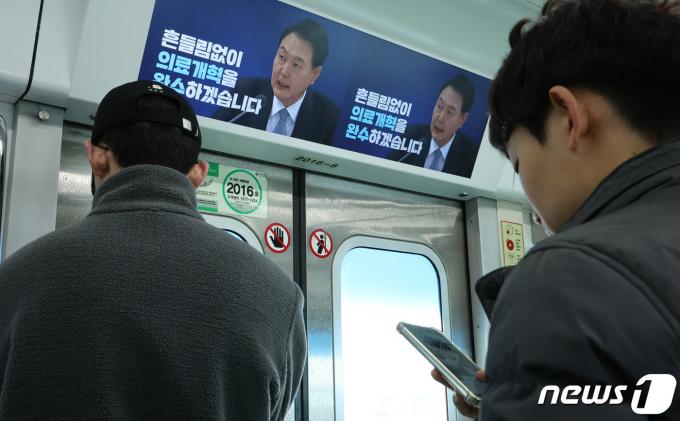 전공의들의 의료 현장 이탈이 장기화하고 있는 가운데 12일 서울 지하철 2호선에 정부의 '의료개혁 완수' 광고가 송출되고 있다. 2024.3.12/뉴스1 ⓒ News1 신웅수 기자