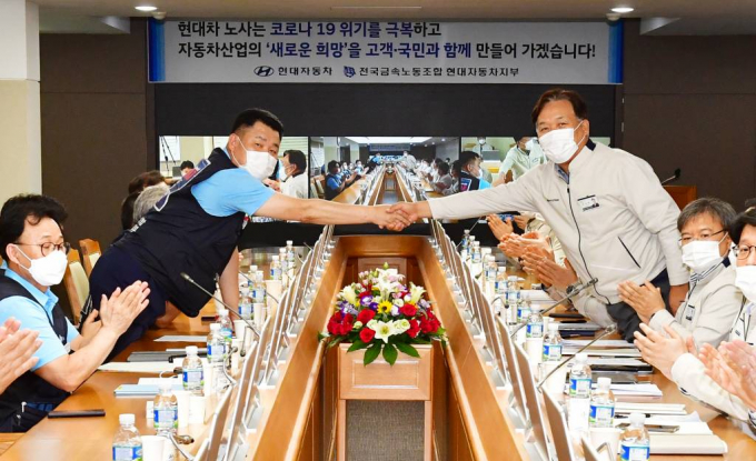 2020년도 임금협상 타결 조인식이 열린 가운데 하언태 사장(오른쪽)과 이상수 노조 지부장이 악수를 하고 있다. (사진=현대자동차 제공)