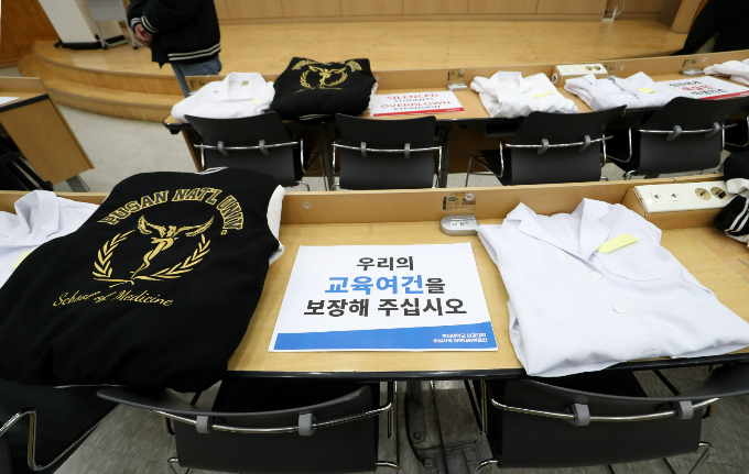 정부가 전공의와 의대 교수들의 공백을 메우기 위해 군의관·공보의 투입을 늘린 가운데 이에 반발한 의대생들이 대거 현역 입대할 것으로 보인다. 사진은 부산대 양산캠퍼스 의과대학에서 열린 부산대 의과대학 교수협의회의 의대 정원 확대 사태에 대한 2차 기자회견에서 책상에 의대생의 가운 등이 놓여진 모습. /사진=뉴스1