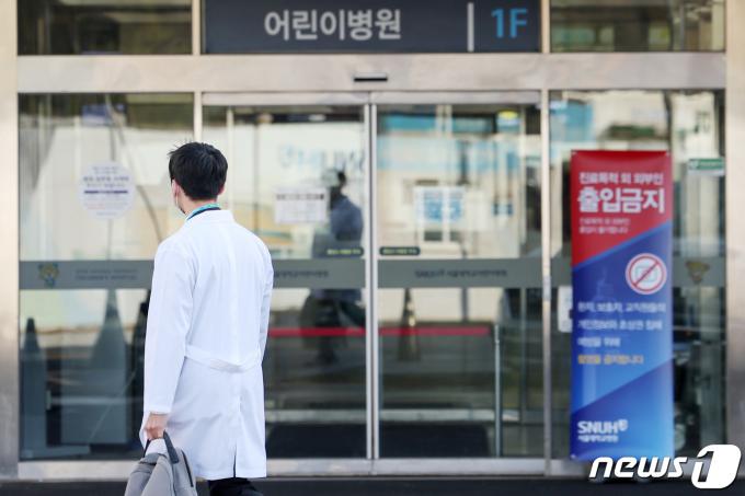 전공의들의 집단행동이 한 달째를 맞은 18일 서울의 한 대학병원에서 한 의사가 어린이병원 앞을 지나고 있다.  2024.3.18/뉴스1 ⓒ News1 민경석 기자