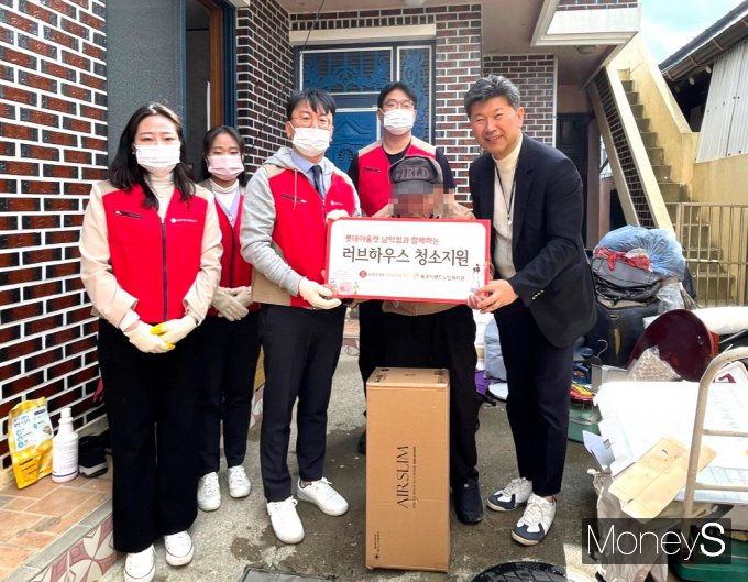 김대홍 롯데아울렛 남악점장(오른쪽)과 직원들이 20일 목포의 한 독거노인 가구를 방문해 봄맞이 대총소 봉사활동을 실시한 후 무선청소기를 전달하고 있다/사진=롯데백화점 홍보 3팀 제공.