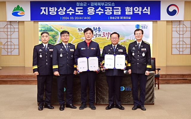 윤경희 청송군수(왼쪽 세번째)와 최진규 경북북부제1교도소장(오른쪽 두번째)이 용수공급을 위한 업무협약을 체결한 뒤 협약서를 들어보이고 있다./사진제공=경북 청송군