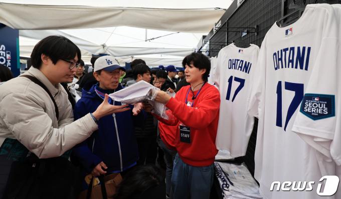 20일 서울 구로구 고척스카이돔에서 열리는 2024 미국 메이저리그(MLB) 월드투어 서울시리즈 개막전 샌디에이고 파드리스와 로스엔젤레스(LA) 다저스의 경기를 앞두고 야구팬들이 기념품샵에서 오타니 유니폼을 구매하고 있다. 이번?경기는?한국에서?열리는?최초의?메이저리그?공식?경기다.?2024.3.20/뉴스1 ⓒ News1 김진환 기자
