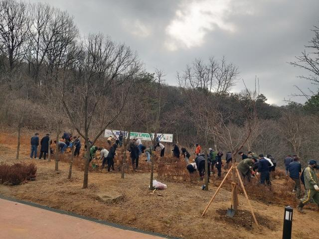 19일 초막골생태공원과 초막동천폭포 사이의 임야에서 하은호 시장을 비롯한 공무원들이 식목일 기념 나무심기 행사에 참여하고 있다. / 사진제공=군포시