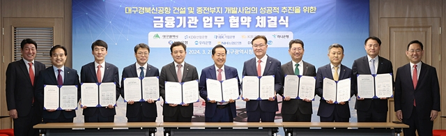 홍준표 대구시장(왼쪽에서 여섯번째)이 각 은행 대표자들과 '대구·경북(TK)신공항 건설 개발사업 성공적 추진'을 위한 업무협약을 체결한 뒤 협약서를 들어보이고 있다./사진제공=DGB대구은행