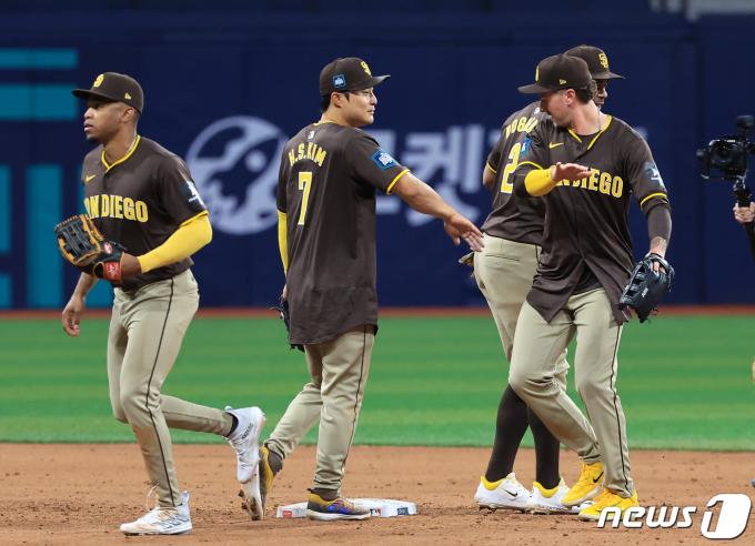 21일 서울 구로구 고척스카이돔에서 열린 2024 미국 메이저리그(MLB) 월드투어 서울시리즈 공식 개막전 샌디에이고 파드리스와 LA 다저스의 2차전 경기, 15대11 승리를 거둔 샌디에이고 김하성이 선수들과 기쁨의 하이파이브를 하고 있다. 2024.3.21/뉴스1 ⓒ News1 김진환 기자