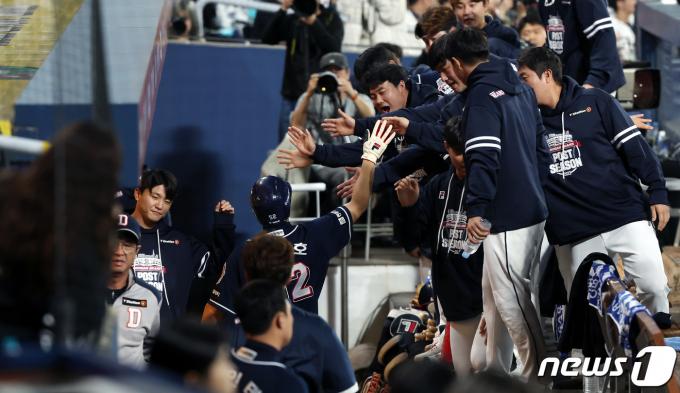 19일 오후 경남 창원NC파크에서 열린 프로야구 '2023 신한은행 SOL KBO 포스트시즌' 와일드카드 결정전 1차전 두산 베어스와 NC 다이노스의 경기, 1회초 1사 2,3루 두산 양의지의 1타점 내야땅볼 때 3루주자 김재호가 선취득점을 올린 뒤 팀원들과 하이파이브 나누고 있다. 2023.10.19/뉴스1 ⓒ News1 이동해 기자