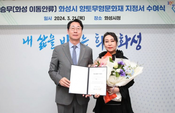 정명근 화성시장(왼쪽)이 향토무형문화재 1호인 '승무(화성 이동안류)'의 보유자로 지정한 김정아씨에게 지정서를 전달한뒤 기념촬영을 하고 있다. / 사진제공=화성시