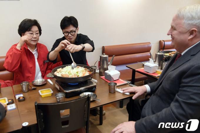 한동훈 국민의힘 총괄선거대책위원장이 25일 서울 중구 신당동 떡볶이 타운 한 식당을 이혜훈 중구성동구을 후보, 국민의미래 인요한 선거대책위원장과 함께 찾아 떡볶이를 주문하고 국자를 들어 음식을 섞고 있다. (공동취재) 2024.3.25/뉴스1 ⓒ News1 임세영 기자