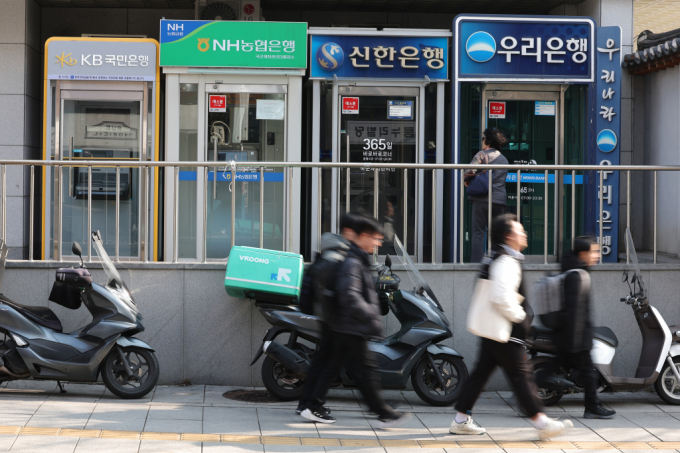 홍콩 ELS 사태로 손실규모가 2조원 가량 예상되는 은행권이 올해도 영업점 통폐합을 통해 내실경영을 꾀할 것으로 보인다. 사진은 서울 시내에 설치된 시중은행 ATM 기기 앞을 시민들이 지나가고 있다./사진=뉴스1