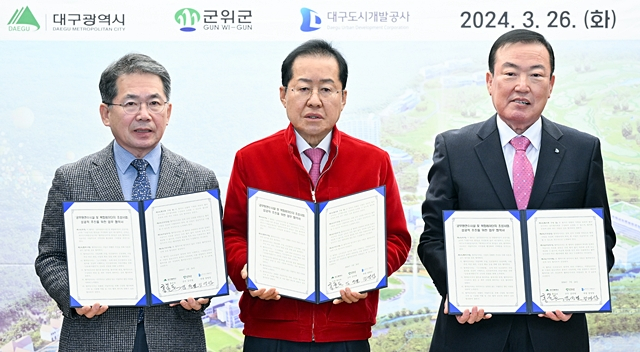 김진열 군위군수(왼쪽부터)와 홍준표 대구시장, 정명섭 대구도시개발공사 사장이 업무협약을 체결한 뒤 기념촬영을 하고 있다./사진제공=대구광역시