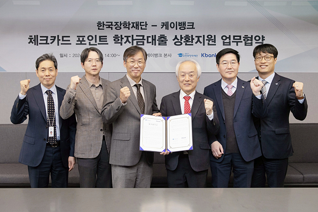 배병일 장학재단 이사장(왼쪽 네번째)이 케이뱅크 관계자들과 학자금대출 상환 제휴 체크카드 도입을 위한 업무협약서를 들어보이고 있다./사진제공=한국장학재단