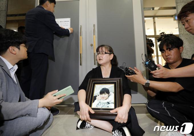 학교폭력 소송에 불출석해 물의를 빚은 권경애 변호사의 징계위원회가 열리는 19일 서울 서초구 대한변호사협회 회관에서 영정 사진을 든 학교폭력 피해자 유족이 권 변호사의 징계 수위 결정을 앞두고 그의 영구 제명을 촉구하며 징계위원들을 기다리고 있다. 2023.6.19/뉴스1 ⓒ News1 박지혜 기자