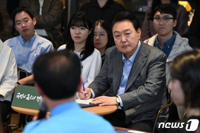 윤석열 대통령이 지난해 11월1일 서울 마포구의 한 카페에서 열린 제21차 비상경제민생회의에서 참석자들의 발언을 메모하고 있다. (대통령실 제공) 2023.11.1/뉴스1 ⓒ News1 오대일 기자