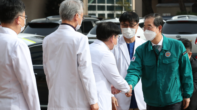 한덕수 국무총리가 27일 오후 4시쯤 대전 중구 충남대병원 의·생명 융합연구센터를 방문해 의대 교수들을 만나 미복귀 전공의들과의 대화 협의를 호소했다. 사진은 이날 오후 충남대병원에서 의료진과 악수하는 한 총리. /사진=뉴스1