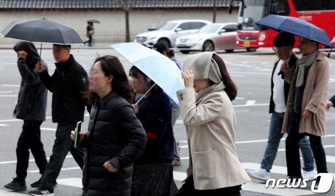 봄비가 내린 25일 오후 서울 종로구 경복궁 인근에서 우산을 준비하지 못한 시민이 옷으로 비를 피하고 있다. 2024.3.25/뉴스1 ⓒ News1 장수영 기자