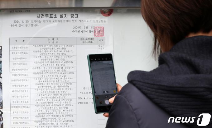 25일 서울 중구 을지로동 주민센터에 게시된 사전투표 4.10 제22대 국회의원 선거 사전투표소 설치 공고문을 한 시민이 촬영하고 있다. 사전투표는 다음달 5일에서 6일 이틀 동안 가능하다. 본투표는 다음달 10일이다. 2024.3.25/뉴스1 ⓒ News1 김성진 기자