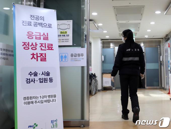 의대 증원에 반발한 전공의 집단 이탈 사태가 4주차로 접어든 11일 경남 양산시 물금읍 양산부산대병원 응급실에 설치된 전공의 진료 공백으로 응급실 정상 진료 차질을 알리는 안내판 앞으로 119구급대원이 지나가고 있다. 정부는 이날부터 4주 동안 군의관 20명과 공중보건의 138명 등 모두 158명을 병원 20곳에 파견해 비상진료체계를 강화한다고 밝혔다. 2024.3.11/뉴스1 ⓒ News1 윤일지 기자
