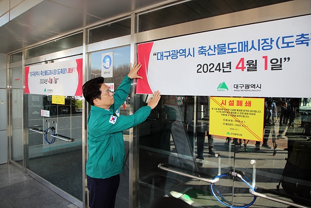 안중곤 대구시 경제국장이 1일 대구시 축산물도매시장 시설폐쇄 안내를 위한 현수막을 걸고 있다./사진제공=대구광역시