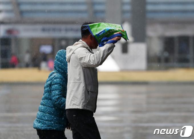 봄비가 내리는 28일 오후 부산 해운대구 벡스코 광장에서 한 시민이 가방으로 비를 피하고 있다. 2024.3.28/뉴스1 ⓒ News1 윤일지 기자