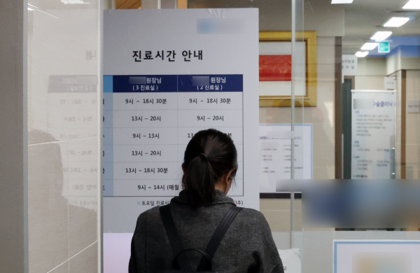 개원의들이 이번달부터 주 40시간으로 진료를 축소하기로 한 가운데 개원의 진료 축소 참여율에 대해 의견이 엇갈린다. 지난 1일 서울의 한 의원을 찾은 시민이 진료시간 안내문을 살피고 있다. /사진=뉴시스