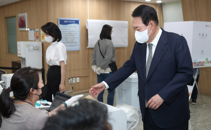윤석열 대통령이 4·10 총선 사전투표 하루 전날인 4일 투표를 독려했다. 사진은 윤 대통령이 제8회 전국동시지방선거 사전투표 첫날인 지난 2022년 5월27일 서울 용산구 용산구의회에 마련된 사전투표소에서 투표용지를 받고 있는 모습. /사진=뉴시스(대통령실통신사진기자단) 