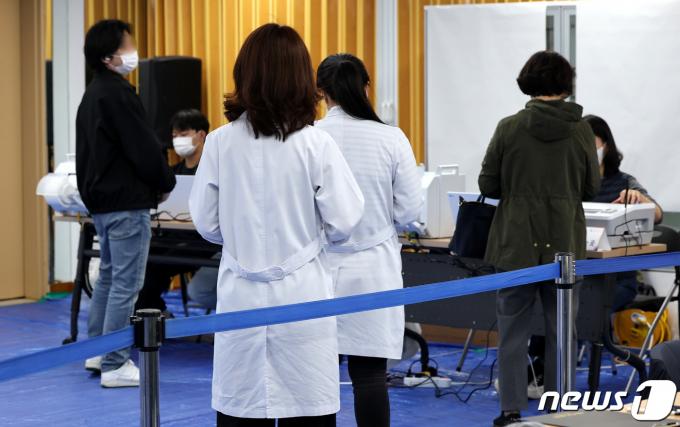 제22대 국회의원선거 사전투표일 첫날인 5일 서울의 한 사전투표소에서 의사와 의료진이 투표순서를 기다리고 있다. 2024.4.5/뉴스1 ⓒ News1 박지혜 기자