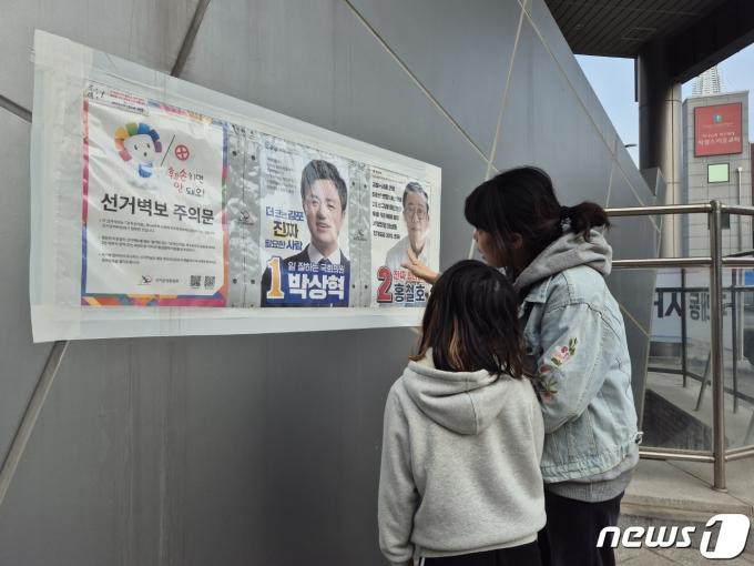 4·10 총전 사전투표 둘째날인 6일 오전 경기 김포시 구래동 행정복지센터 사전투표소를 찾은 김 씨(45)가 자신의 딸에게 후보자 공약에 대해 설명하고 있다.2024.04.06 ⓒ News1 이시명 기자