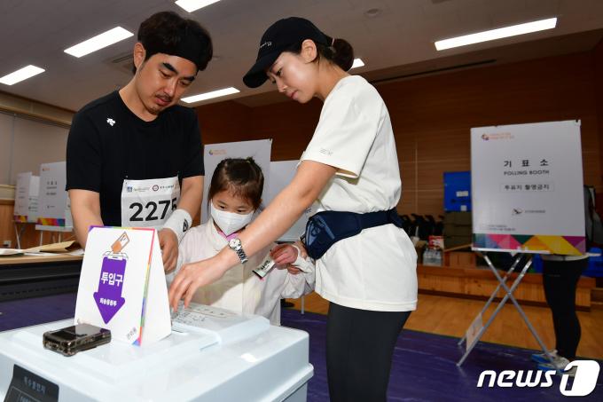 제22대 국회의원선거 사전투표일 이틀째인 6일 오전 경북 경주시 보덕동 사전투표소에서 제31회 경주벚꽃마라톤대회에 참가하기 위해 김해에서 온 지율이네 가족이 출발에 앞서 소중한 한 표를 행사하고 있다. 2024.4.5/뉴스1 ⓒ News1 최창호 기자