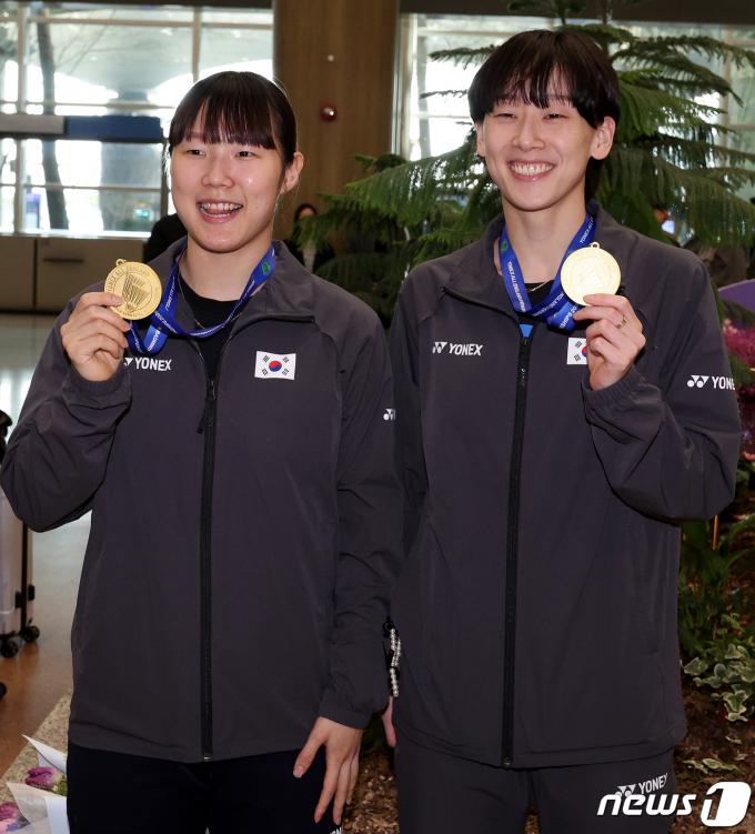 여자 배드민턴 대표팀 백하나(왼쪽)와 이소희가 19일 오후 인천국제공항 제1터미널을 통해 귀국한 뒤 전영오픈 여자 복식 금메달을 들어보이고 있다. 2024.3.19/뉴스1 ⓒ News1 장수영 기자