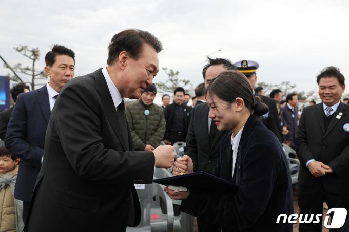 윤석열 대통령이 지난달 22일 오후 경기 평택시 해군2함대사령부에서 열린 제9회 서해수호의 날 기념식에 참석해 천안함 피격 당시 목숨을 잃은 고(故) 김태석 원사 딸 김해봄 씨와 주먹을 부딪히고 있다. (대통령실 제공) 2024.3.22/뉴스1 ⓒ News1 안은나 기자