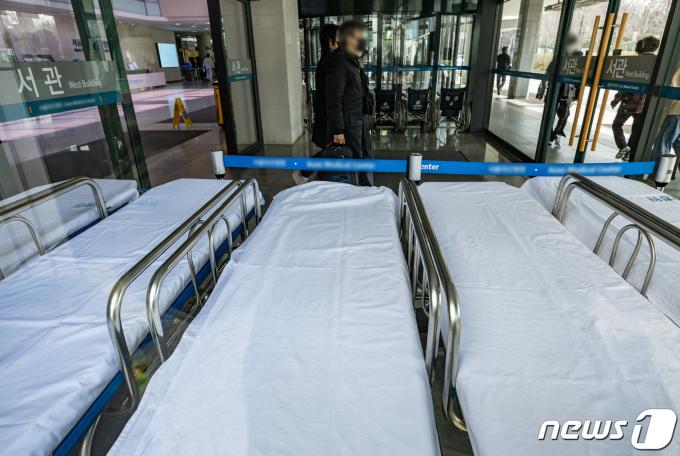 정부의 의대 증원에 반발하는 전공의 집단 이탈 사태가 이어지고 있는 27일 오전 서울의 한 대형병원에서 환자 및 보호자들이 병원 로비로 향하고 있다 2024.3.27/뉴스1 ⓒ News1 이재명 기자