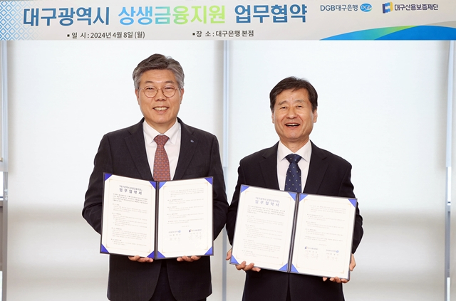 황병우 대구은행장(왼쪽)과 박진우 대구신보 이사장(오른쪽)이 8일 대구 수성동 소재 대구은행 본점에서 상생금융지원을 위한 업무협약을 마친 뒤 협약서를 들어보이고 있다./사진제공=DGB대구은행