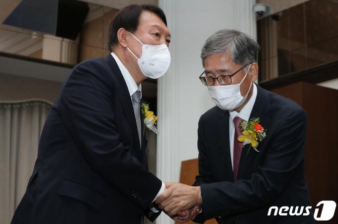 2021년 11월 9일 당시 윤석열 국민의힘 대선후보가 9일 서울 중구 한국프레스센터에서 열린 신평 변호사의 출판기념회에 참석해 신 변호사와 악수하고 있다. 2021.11.9/뉴스1 ⓒ News1 국회사진취재단