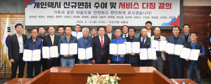 이권재 오산시장(앞줄 오른쪽 일곱번째)이 15일 개인택시 신규면허 대상자 17명에게 면허증을 수여한 뒤  서비스 개선을 다짐하고 있다. / 사진제공=오산시